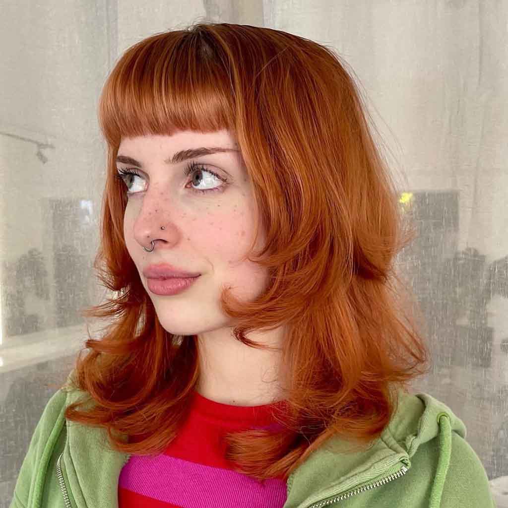 90’s Style Medium Layered Ginger Hair With Blunt Bangs
