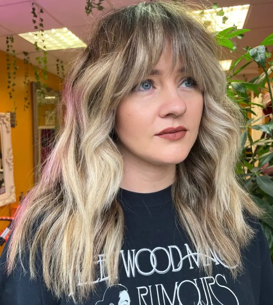Duo-Toned Wolf Cut with Choppy Curtain Bangs on Wavy Hair and Subtle Pink Highlights