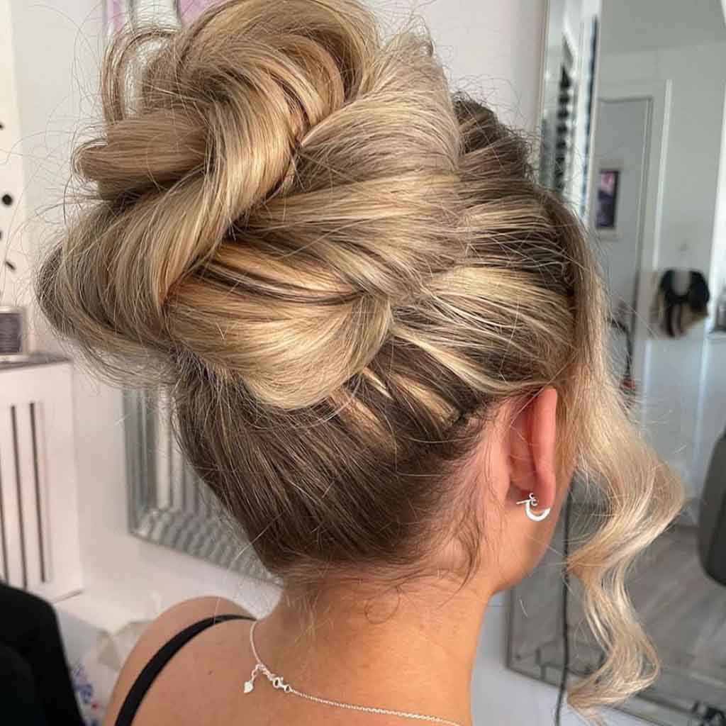 Messy High Bun With Face Framing Tendrils