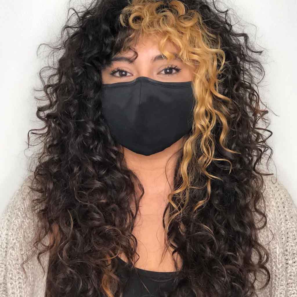 Curly Black Shag Cut With Golden Highlights and Curtain Bangs