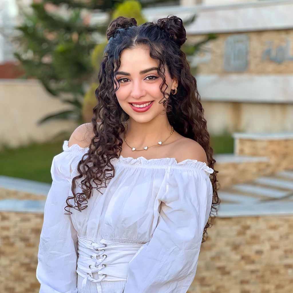 Long Curly Hair With Space Buns and Face-Framing Tendrils